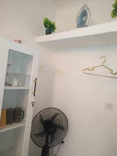 a white room with a fan on a wall at chambre meublée Douala Cameroun, bonapriso, eau chaude, wifi haut débit, clim, gardien in Douala