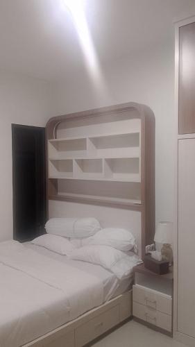 a bedroom with a bed with white sheets and pillows at Kayana Homestay Palu 