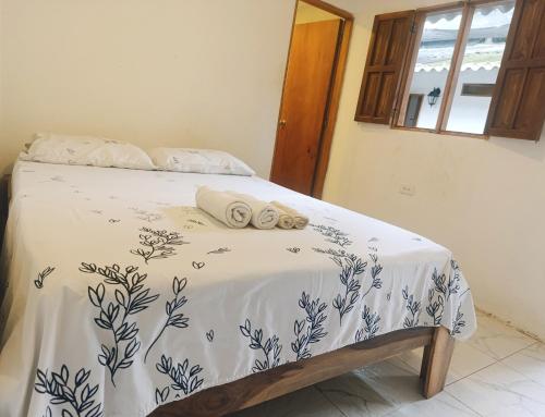 a bed with a blue and white comforter with towels on it at Hermoso Palomino in Palomino