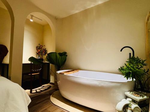 a white bath tub in a room with plants at PINhome in Ho Chi Minh City