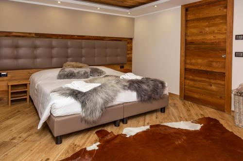 a bedroom with a large bed with a furussed bedsenal at Hotel K2 in Sauze dʼOulx