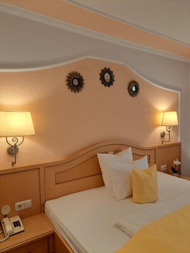 a bedroom with a bed with two clocks on the wall at Schedlers Löwenhotel-GARNI in Alberschwende