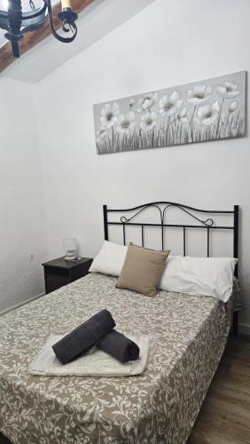 a bedroom with a bed with a painting on the wall at CASA RURAL SANTA ELENA in Cazalla de la Sierra