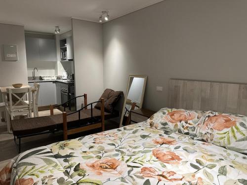 ein Schlafzimmer mit einem Bett mit einer Blumendecke darauf in der Unterkunft Departamento Nuevo Full Parque Ohiggins in Santiago