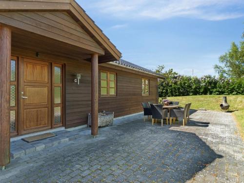 a house with a patio with a table and chairs at Holiday Home Nantje - 560m to the inlet by Interhome in Jægerspris