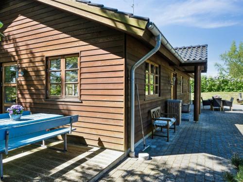 a wooden house with a blue bench in front of it at Holiday Home Nantje - 560m to the inlet by Interhome in Jægerspris