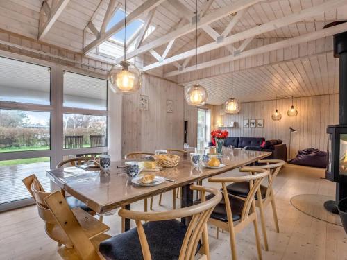 a dining room with a large wooden table and chairs at Holiday Home Mira - 500m from the sea by Interhome in Gedser