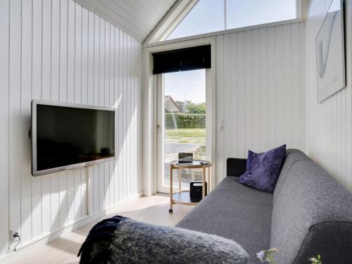 a living room with a couch and a flat screen tv at Holiday Home Solfrid - 150m from the sea by Interhome in Esbjerg