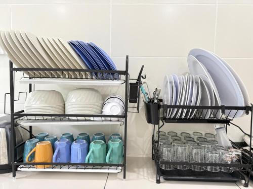 a shelf in a kitchen with plates and dishes at Sekinchan 2008 Homestay KaraokeBBQ 20pax 三层简约风名宿 in Sekincan