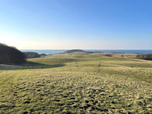 an open field with the ocean in the background at Holiday Home Uschi - 86m from the sea by Interhome in Kalundborg