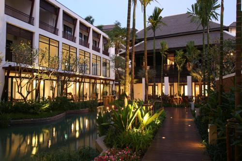 a hotel with a pool in front of a building at Rarin Jinda Wellness Spa Resort in Chiang Mai