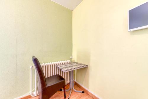 a chair sitting next to a desk in a room at Logis Belledonne in Arvillard