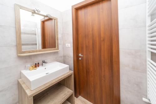 a bathroom with a sink and a wooden door at Hotel K2 in Sauze dʼOulx