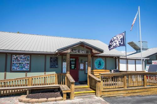 a dive bar with a wooden porch and a flag at Journeys End 203 in Coffeyville