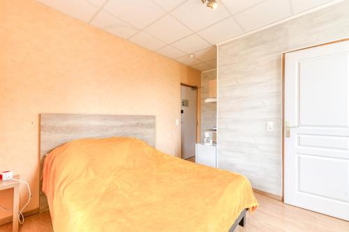 a bedroom with a bed with a yellow blanket at Logis Belledonne in Arvillard