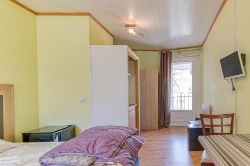 a bedroom with a bed and a table and a tv at Logis Belledonne in Arvillard