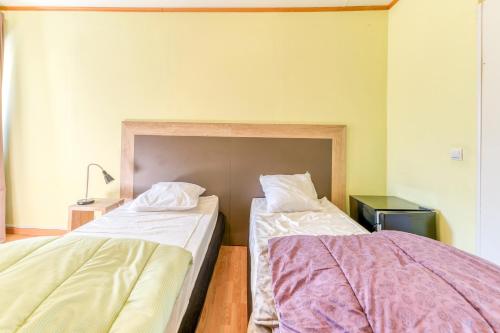 two beds sitting next to each other in a room at Logis Belledonne in Arvillard