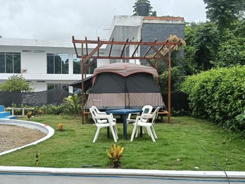 a gazebo with a table and chairs in a yard at Cabaña velez in Capurganá