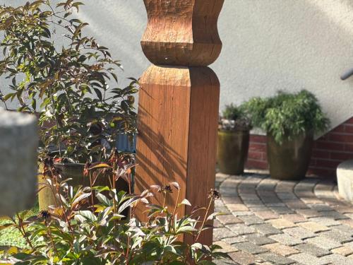 a wooden pole sitting on a sidewalk next to a plant at Pension und Café "Alte Straßenmeisterei" in Hasselfelde