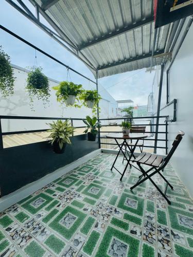 a table and chair on a balcony with plants at Homestay Kim Mỹ in Ấp Rạch Mẹo