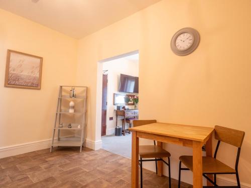 a dining room with a table and a clock on the wall at The Black Boy Inn in Caernarfon
