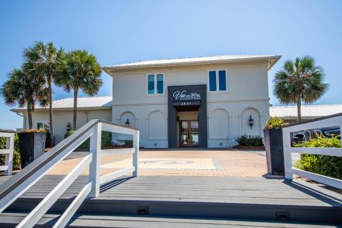 a white building with palm trees in front of it at Whispering Sands 1A in Coffeyville