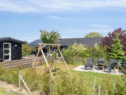a swing set in the yard of a house at Holiday Home Tuulikki - 100m from the sea by Interhome in Nyrup