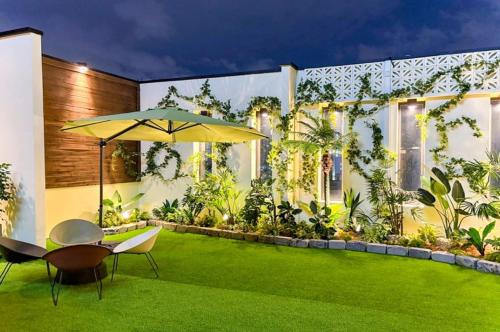 a house with a green yard with an umbrella at Yeongdeungpo Ciel Hotel in Seoul