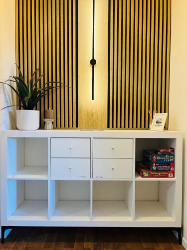 a white desk with a potted plant on top at charmantes Apartment bei Hamburg - Ruhe, Komfort & kostenloses Parken in Rellingen
