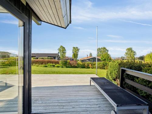 a wooden porch with a bench on a deck at Holiday Home Manfred - 250m from the sea by Interhome in Rønde