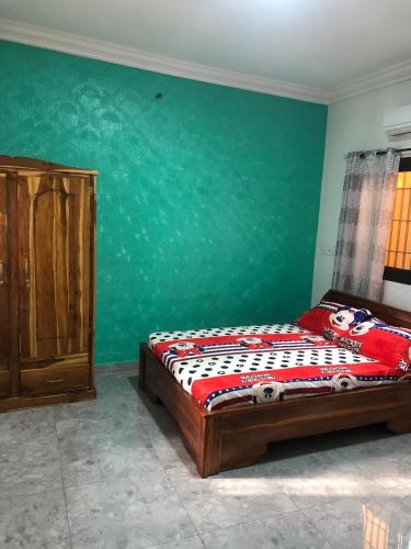 ロメにあるla Maison de rêve à Loméのベッドと緑の壁のある寝室