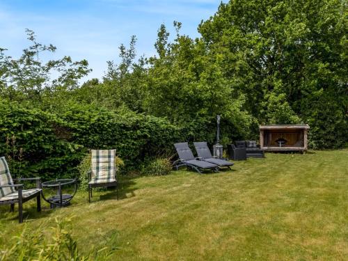 a group of chairs sitting in the grass in a yard at Holiday Home Fenna - 30km from the sea by Interhome in Toftlund
