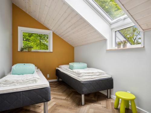 two beds in a room with two windows at Holiday Home Fenna - 30km from the sea by Interhome in Toftlund