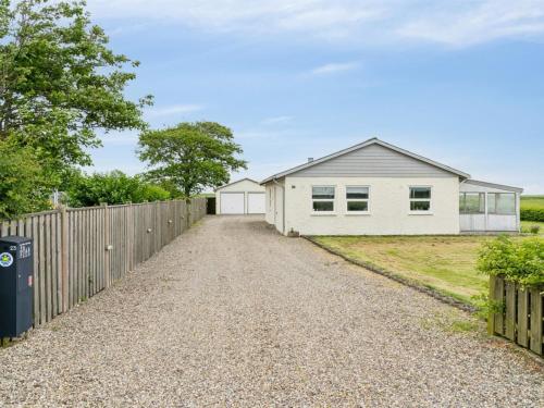 a house with a fence and a gravel driveway at Holiday Home Janin - 400m from the sea by Interhome in Højer