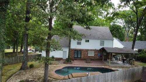 a house with a swimming pool in the yard at Modern Vast Southern Home with Pool Near Shops in Memphis