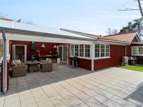 a red house with a patio in front of it at Holiday Home Tarje - 320m from the sea by Interhome in Rønne
