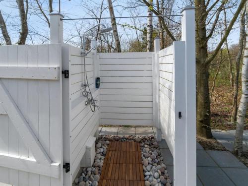 a white fence with a wooden walkway at Holiday Home Tarje - 320m from the sea by Interhome in Rønne