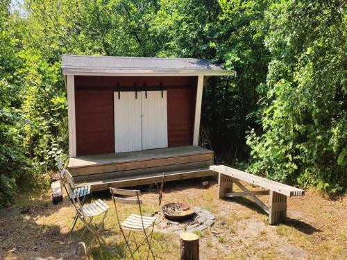 a small out house with a bench and a porch at Holiday Home Tarje - 320m from the sea by Interhome in Rønne