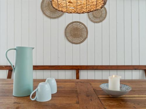 a table with a blue vase and a candle on it at Holiday Home Tarje - 320m from the sea by Interhome in Rønne
