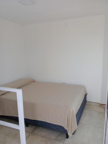 a bed in a room with a white wall at TERREdO in Neuquén