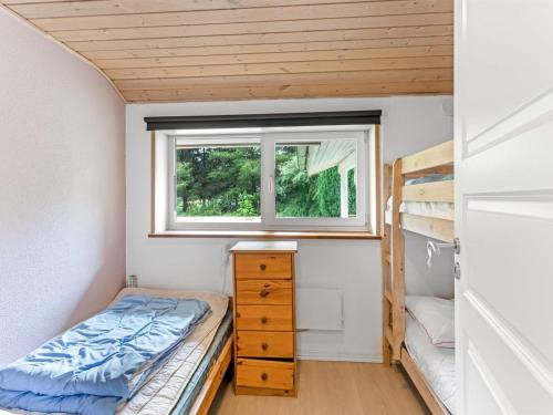 a small bedroom with a bed and a window at Holiday Home Samine - 2km from the sea by Interhome in Bøstrup