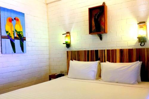 a bedroom with a bed with two birds on the wall at Suites by Eco Hotels in El Nido