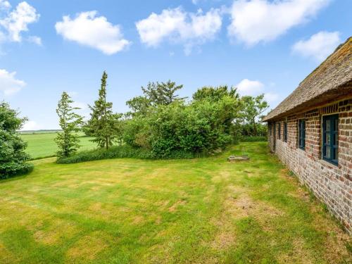 an old stone house with a grass yard next to a building at Holiday Home Claus - 1-5km to the fjord by Interhome in Tim