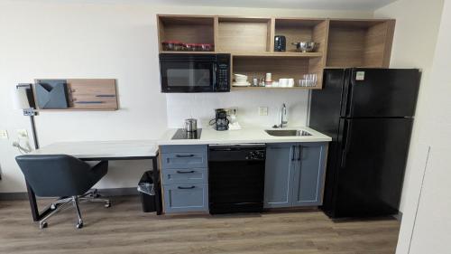 a kitchen with a black refrigerator and a sink at Candlewood Suites Conway by IHG in Conway