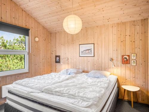 a bedroom with a large bed in a wooden wall at Holiday Home Elisenda - 1km from the sea by Interhome in Torsted