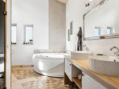 a white bathroom with two sinks and a tub at Holiday Home Romil - 2-1km from the sea by Interhome in Højby