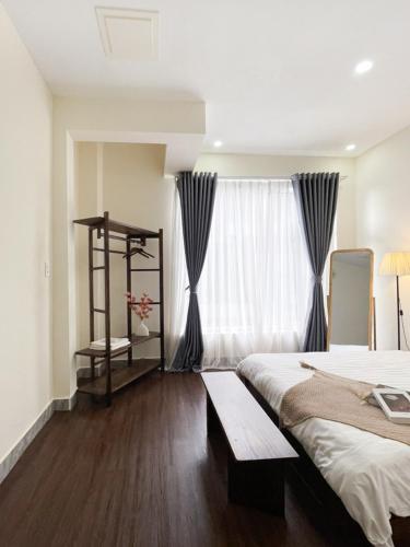 a bedroom with a large bed and a window at Little Chái Nho - The Flow in Da Lat