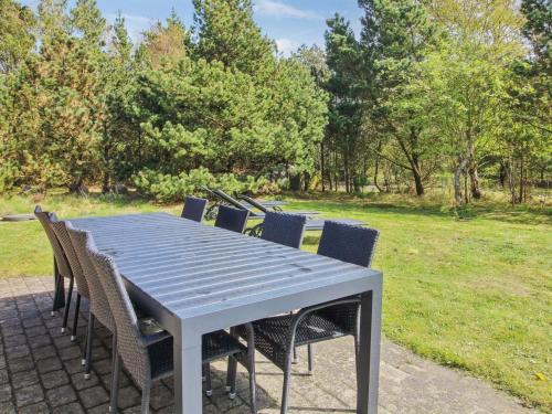 a blue table and chairs in a park at Holiday Home Alina - 1km from the sea by Interhome in Mølby