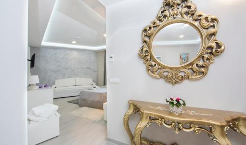 a living room with a mirror and a table at Boutique Hotel Melissa in Poreč