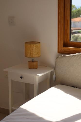 a lamp on a table next to a bed at Stay and Nest Casa Alba Modern Boho Villa with private Pool near to Sea, Paphos in Peyia